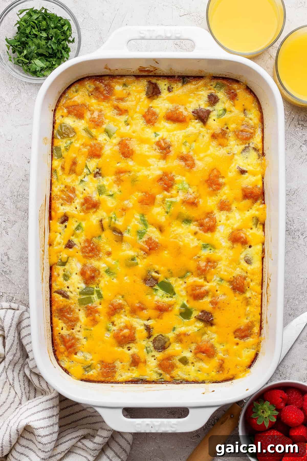 baked sweet potato breakfast casserole with melted cheddar cheese in white dish