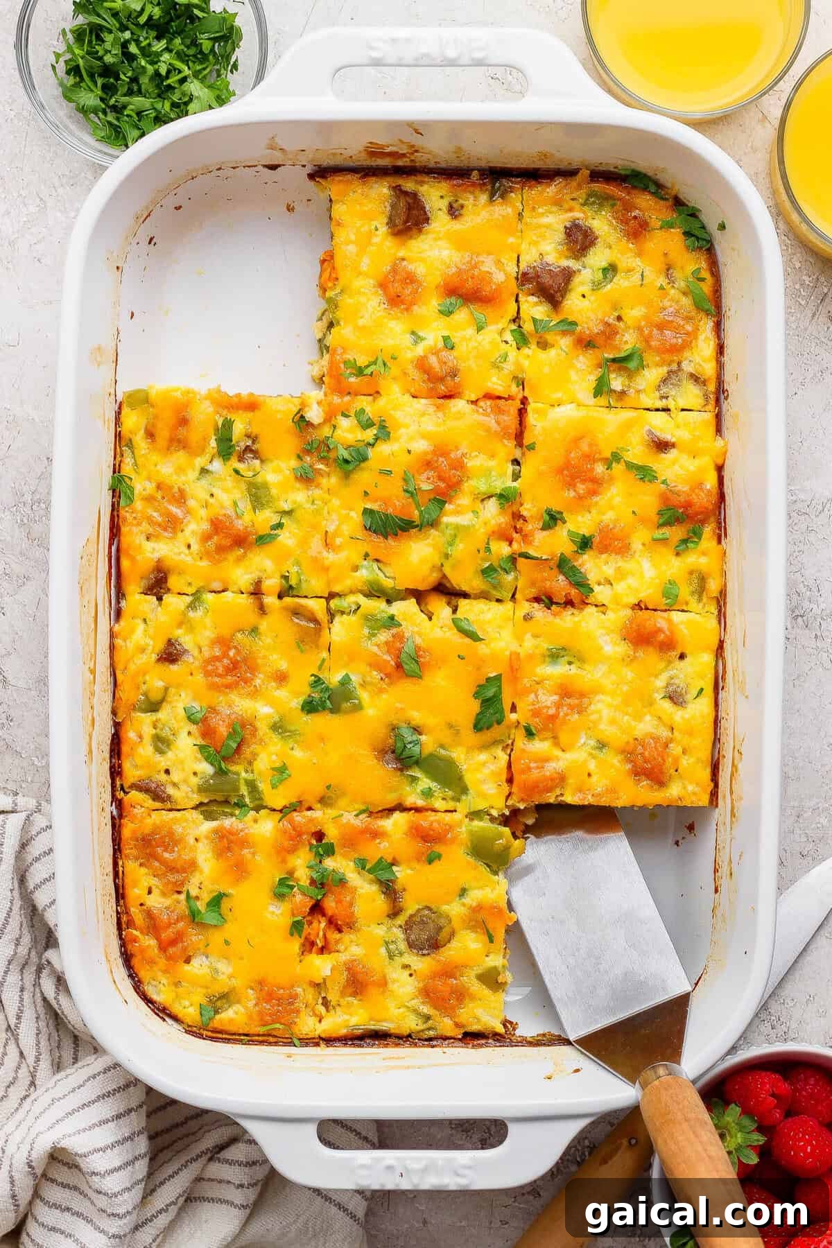 sweet potato breakfast casserole sliced into squares with a piece being lifted out