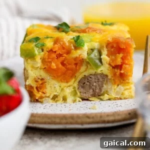 plated slice of sweet potato breakfast casserole showing layers of tater tots and sausage