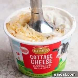 Soft golden onions added to smooth blended cottage cheese dip before pulsing.